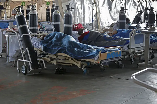 Patients are seen lying on hospital beds inside a temporary ward dedicated to the treatment of possible COVID-19 coronavirus patients at Steve Biko Academic Hospital in Pretoria on January 11, 2021. (Photo by Phill Magakoe/AFP Photo)