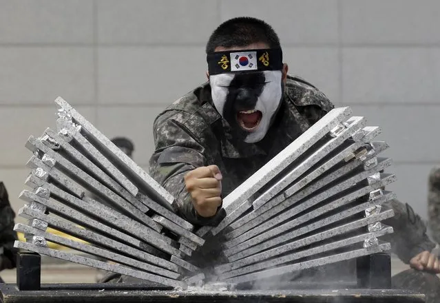 A South Korean soldier breaks stone plates by his arm during an anti-terror drills ahead of the 4th Asian Indoor and Martial Arts Games Incheon, which starts from the end of June, in Incheon, west of Seoul, South Korea, Thursday, June 13, 2013. The drills was held against possible terrorists' attack while the threat of terrorism in various sports games are increasing after Boston Marathon terror. (Photo by Lee Jin-man/AP Photo)