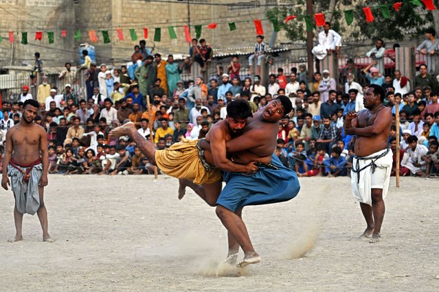 Wrestlers compete in a 'Sindhi Malakhra' wrestling match, an ancient form of wrestling that originated in Pakistan's Sindh region, during a local tournament in Karachi on October 21, 2025. (Photo by Asif Hassan/AFP Photo)