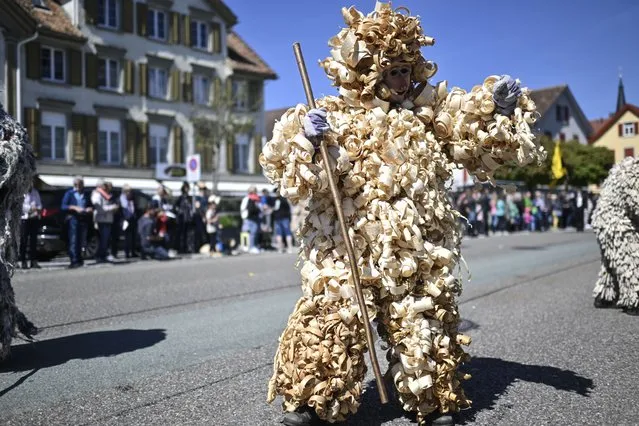 Men wearing costumes made of wood chips take part in the egg-hunt-feast in Oberriet, Switzerland, 18 April 2022. The tradition takes place each five years. After a parade, members of the so-called “Gruenen” and “Duerren” (lit. greens and leans) fight against each other to symbolize spring's victory ofter winter time. (Photo by Gian Ehrenzeller/EPA/EFE)