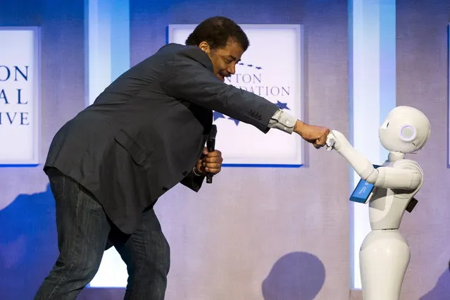 Astrophysicist Neil deGrasse Tyson interacts with Pepper, a social humanoid robot developed by Aldebaran for SoftBank, during the Clinton Global Initiative's annual meeting in New York, September 28, 2015. (Photo by Lucas Jackson/Reuters)