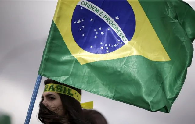A demonstrator carries a Brazilian national flag during a protest calling for the impeachment of Brazil's President Dilma Rousseff near the National Congress in Brasilia, Brazil, December 13, 2015. (Photo by Ueslei Marcelino/Reuters)