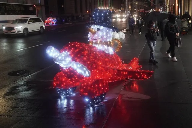 A plane made of Christmas lights called “Magic Delivery” sits on the sidewalk along Fifth Avenue during a holiday season installation in the Manhattan borough of New York City, New York, December 4, 2020. (Photo by Carlo Allegri/Reuters)