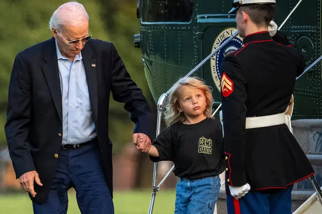President Joe Biden helps his grandson Beau Biden off Marine One upon arrival at Fort McNair, Sunday, June 25, 2023, in Washington. The Biden's are returning from Camp David. (Photo by Andrew Harnik/AP Photo)
