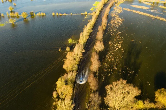 A vehicle travels along the A110 near Welney in Welney, UK, United Kingdom during flooding due to Seasonal weather on December 15, 2020. (Photo by Terry Harris/Rex Features/Shutterstock)