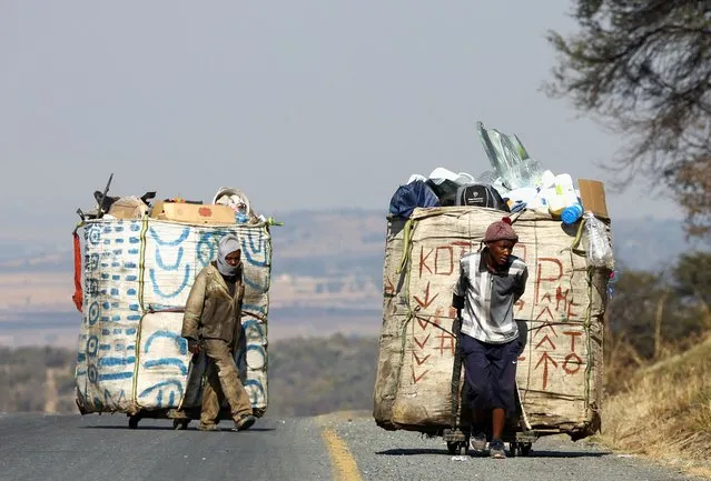 Steven Lesoona and Thabang Pule, waste pickers, pull trolleys loaded with recyclable materials, as they combat unemployment in Naturena, near Johannesburg, South Africa on July 3, 2023. (Photo by Siphiwe Sibeko/Reuters)