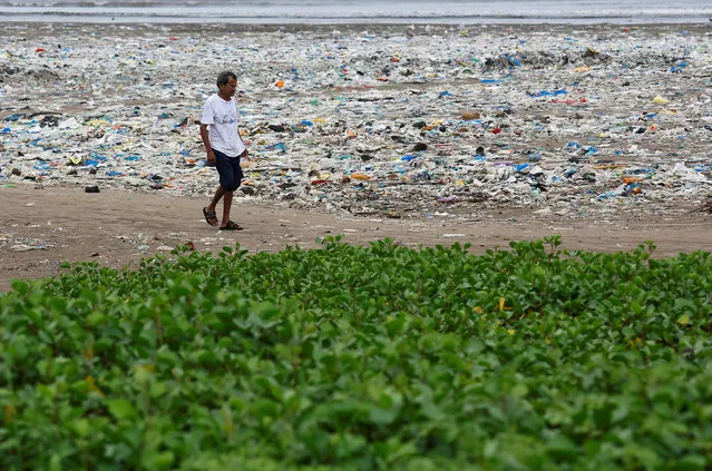 A man walks on a garbage-strewn beach in Mumbai, India, July 25, 2018. (Photo by Francis Mascarenhas/Reuters)