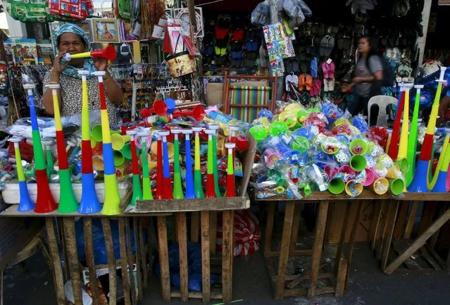A saleswoman blows a plastic horn to attract customers at her stall ahead of New Year's eve celebration in Manila, December 29, 2015. (Photo by Romeo Ranoco/Reuters)