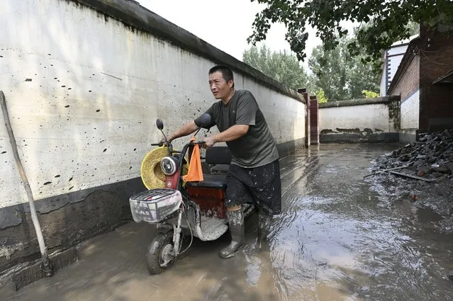 A local resident cleans up his house in the aftermath of flooding from heavy rains in Zhuozhou city, in northern China's Hebei province on August 9, 2023. China's capital has been hit by record downpours in recent weeks, damaging infrastructure and deluging swaths of the city's suburbs and surrounding areas. In Hebei province, which neighbours Beijing, 15 were reported to have died and 22 were missing. (Photo by Jade Gao/AFP Photo)