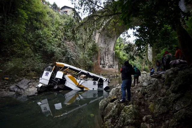 Media workers film the wreckage of a bus which ran off a highway bridge in Atoyac in Veracruz state, Mexico, January 10, 2016. (Photo by Yahir Ceballos/Reuters)