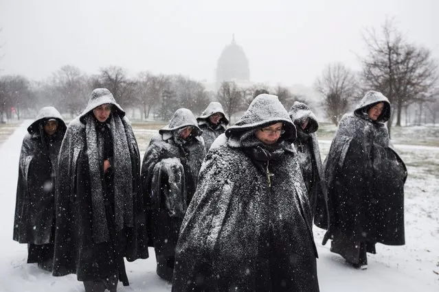 A group of nuns visiting Washington, DC from their convent in Chicago walk in the early snow from a major blizzard outside the U.S. Capitol in Washington, DC, USA, 22 January 2016. A major blizzard, Winter Storm Jonas, is expected to dump over two feet (61 centimeters) of snow in the mid-Atlantic region this coming weekend. (Photo by Jim Lo Scalzo/EPA)