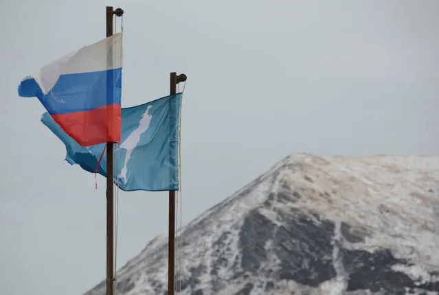 A national flag of Russia and a flag of Russia's Sakhalin region flutter in the village of Malokurilskoye on the island of Shikotan, Southern Kuriles, Russia, December 18, 2016. (Photo by Yuri Maltsev/Reuters)