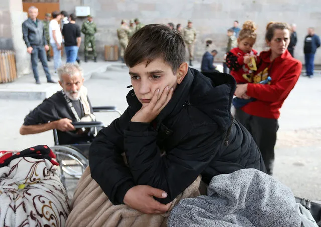 A refugee boy from Nagorno-Karabakh region waits upon his arrival at a temporary accommodation centre in the town of Goris, Armenia on September 25, 2023. (Photo by Irakli Gedenidze/Reuters)