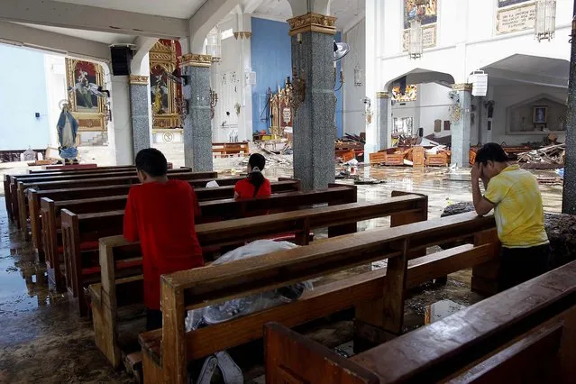 Residents pray inside a damaged church in Tacloban city. (Photo by Romeo Ranoco/Reuters)