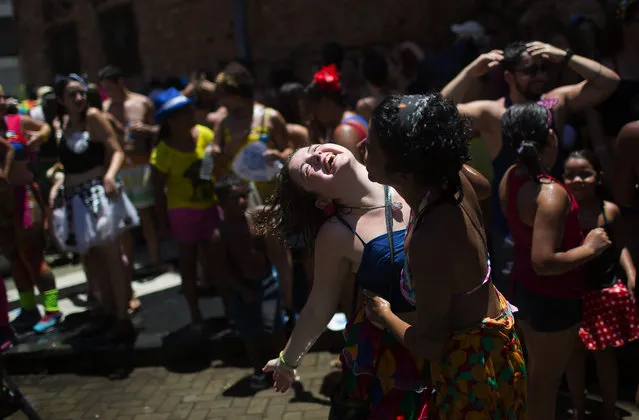 Women dance during the “Escravos da Maua” block party, as part of pre-Carnival celebrations in Rio de Janeiro, Brazil, Sunday, January 31, 2016. Merrymakers are taking to the streets in hundreds of open-air “bloco” parties before the start of the city's over-the-top Carnival, which officially starts the first week of February, the highlight of the year for many residents. “Escravos da Maua” translates as Slaves of Maua. (Photo by Leo Correa/AP Photo)
