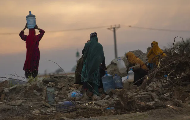 In this January 20, 2017, photo, villagers collect clean water from a broken water supply line in the suburbs of Islamabad, Pakistan. Pakistan says it will seek a bailout loan from the International Monetary Fund to address a mounting balance of payments crisis, Finance Minister Asad Umar said Monday. (Photo by B.K. Bangash/AP Photo)