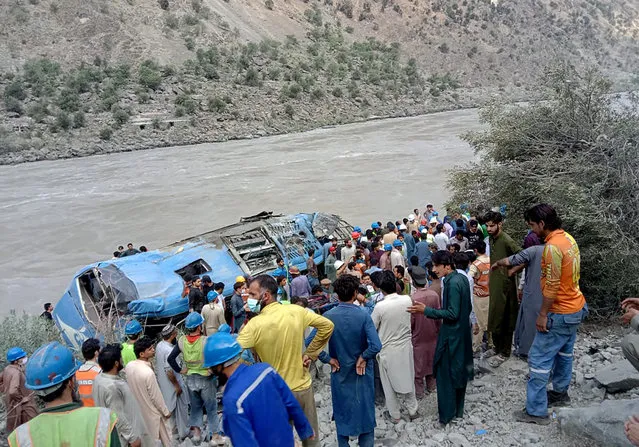 Local residents and rescue workers gather at the site of bus accident, in Kohistan Kohistan district of Pakistan's Khyber Pakhtunkhwa province, Wednesday, July 14, 2021. A bus carrying Chinese and Pakistani construction workers on a slippery mountainous road in northwest Pakistan fell into a ravine Wednesday, killing a dozen of people, including Chinese nationals, and dozens were injured, a government official said. (Photo by AP Photo/Stringer)