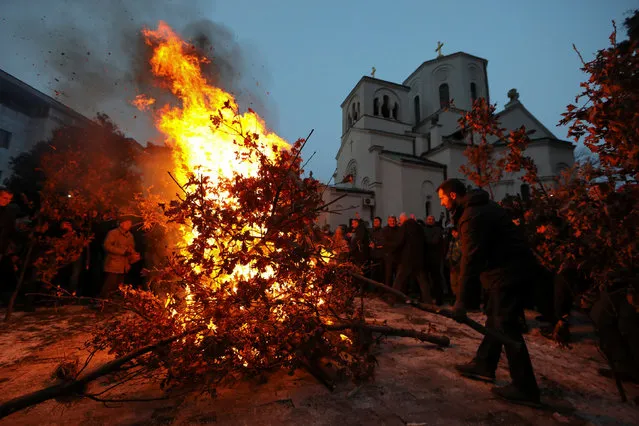 Believers burn dried oak branches, which symbolises the Yule log, on Orthodox Christmas Eve in front of the St. Sava temple in Belgrade, Serbia, January 6, 2017. Serbian Orthodox believers celebrate Christmas on January 7, according to the Julian calendar. (Photo by Marko Djurica/Reuters)