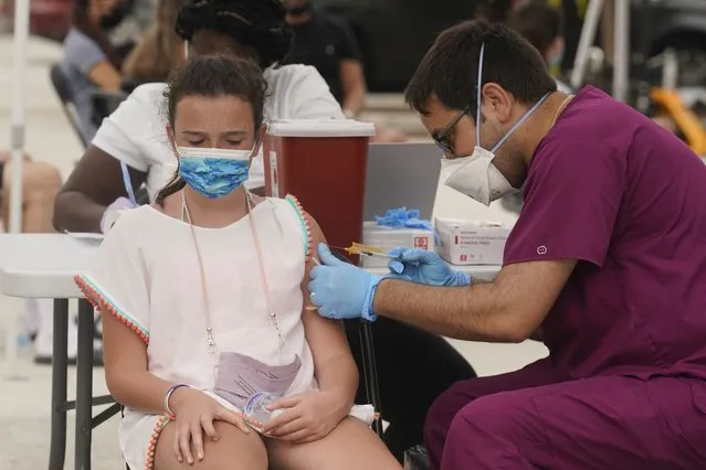 Francesca Anacleto, 12, receives her first Pfizer COVID-19 vaccine shot from nurse Jorge Tase, Wednesday, August 4, 2021, in Miami Beach, Fla. On Tuesday, the CDC added more than 50,000 new COVID-19 cases in the state over the previous three days, pushing the seven-day average to one the highest counts since the pandemic began, an eightfold increase since July 4. (Photo by Marta Lavandier/AP Photo)