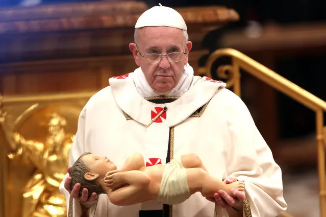 Pope Francis holds the crib effigy of the infant Jesus as he attends the Christmas night mass at the St. Peter's Basilica on December 24, 2013 in Vatican City, Vatican. Pope Francis celebrates the first Christmas of his pontificate. (Photo by Franco Origlia/Getty Images)