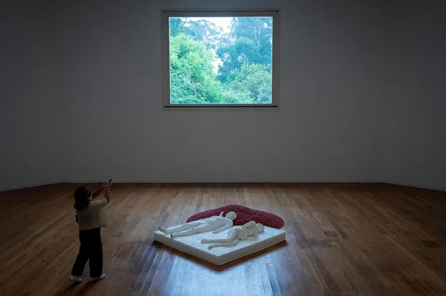 A visitor takes pictures of “Two Figures” by Chinese artist Ai Weiwei during the presentation of his exhibition “Ai Weiwei: Intertwine” at the Serralves Museum of Contemporary Art in Porto on July 22, 2021. (Photo by Miguel Riopa/AFP)