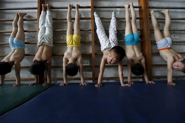 Young gymnasts practice at a gymnasium of a sports school in Jiaxing, Zhejiang province, on April 17, 2015. (Photo by Reuters/Stringer)