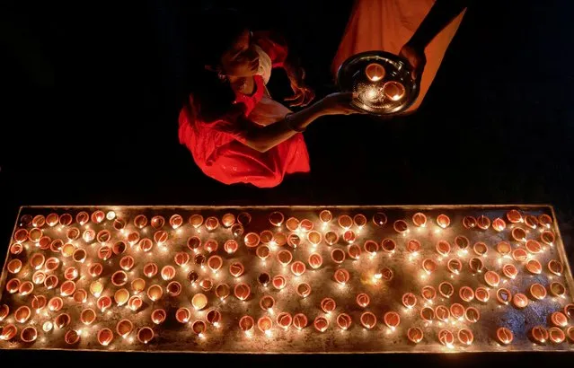 A devotee prepares to place oil lamps at a religious ceremony during the Diwali festival at Ponnambalavaneshwaram Hindu temple in Colombo, Sri Lanka on November 12, 2023. (Photo by Dinuka Liyanawatte/Reuters)