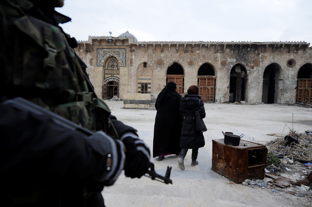 A Syrian army soldier stands guard as visitors walk inside Aleppo's Umayyad mosque, Syria January 31, 2017. (Photo by Omar Sanadiki/Reuters)