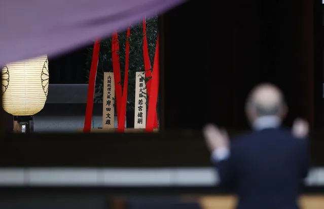 A “masakaki” ritual ornament, center left, bearing the name of Japanese Prime Minister Fumio Kishida, is placed as a man prays at Yasukuni shrine in Tokyo Sunday, October 17, 2021. Kishida donated the offerings Sunday to the Tokyo shrine viewed by China and the Koreas as a symbol of Japanese wartime aggression, though he avoided a visit. (Photo by Masanori Takei/Kyodo News via AP Photo)