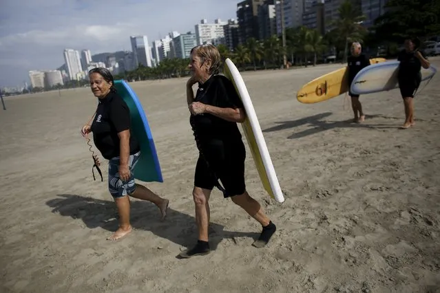 Maria Ines (L), 69, Regina Palomares (2nd L), 68, Edmea Pereira (R), 69, and her husband Francisco Aguiar, 71, walk towards the sea before their surf class in Santos, Sao Paulo state, Brazil March 16, 2016. (Photo by Nacho Doce/Reuters)