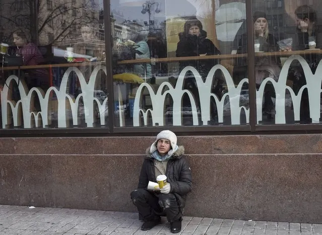 A man begs for money outside a McDonald's restaurant in central Kiev, Ukraine, February 10, 2017. (Photo by Gleb Garanich/Reuters)