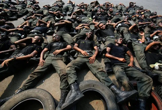 Thai police commandos take a rest during an anti terrorist exercise at Crime Suppression Division in Bangkok, Thailand, Wednesday, February 26, 2014. Violence spread Tuesday to another anti-government protest site in Thailand's capital following weekend explosions that left five people dead, including four children, security officials said. (Photo by Sakchai Lalit/AP Photo)