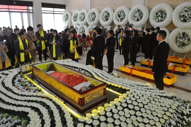 A man lies in a coffin amidst flowers as he takes part in a funeral simulation during an event organized by the local government  promoting for the upcoming Qingming, or Tomb Sweeping Day, at a funeral parlor in Jinhua, Zhejiang province, China March 27, 2019. (Photo by Reuters/China Stringer Network)