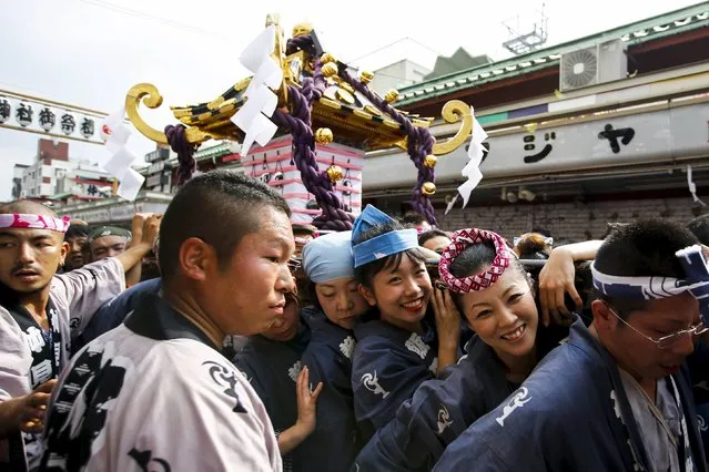 Revellers carry a portable shrine through a narrow row of market stalls outside the Sensoji temple during the Sanja Matsuri festival in the Asakusa district of Tokyo May 17, 2015. (Photo by Thomas Peter/Reuters)