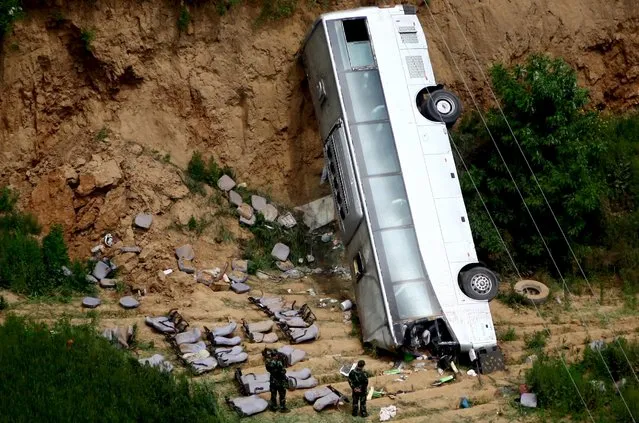 A bus is seen after overturning and falling into a valley in Chunhua county in Xianyang, Shaanxi province, China, May 16, 2015. (Photo by Reuters/Stringer)