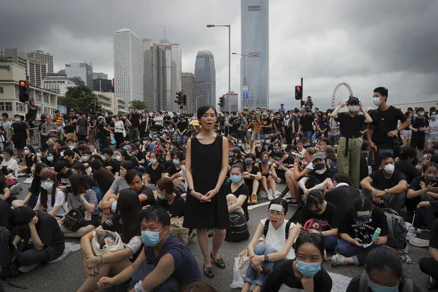 A protester, center, calls Hong Kong Chief Executive Carrie Lam to step down as she and others continue protest against the unpopular extradition bill near the Legislative Council in Hong Kong, Monday, June 17, 2019. A member of Hong Kong's Executive Council says the city's leader plans to apologize again over her handling of a highly unpopular extradition bill. (Photo by Kin Cheung/AP Photo)