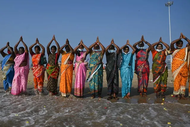 Women perform rituals during a ceremony for the victims of the 2004 tsunami at Pattinapakkam Beach in Chennai on December 26, 2021. (Photo by Arun Sankar/AFP Photo)