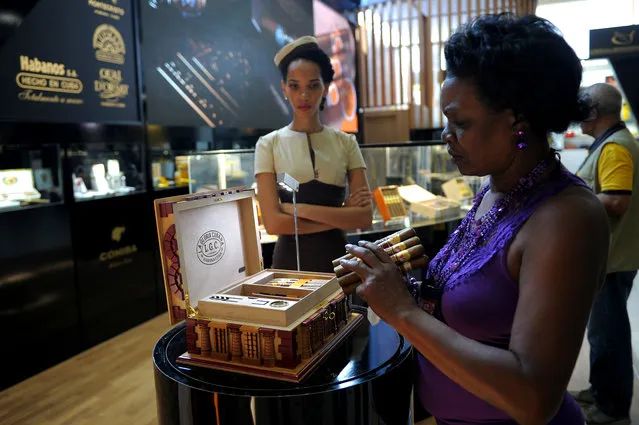 A visitor to the XIX Havana Cigar Festival looks at cigars at the Convention Palace in Havana on February 27, 2017. (Photo by Yamil Lage/AFP Photo)