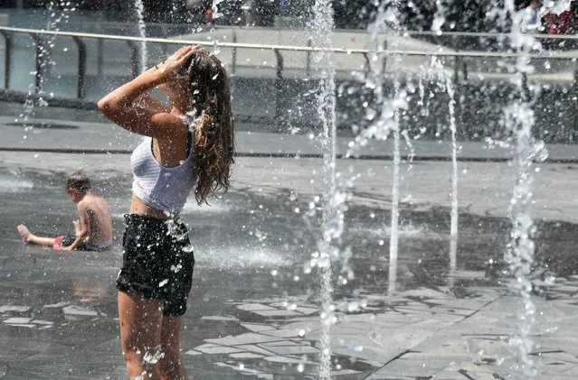 People cools off at a fountain in Milan, Italy, Thursday, June 27, 2019. Temperatures in Northern Italy are forecast to hit 40 C on Thursday. (Photo by Daniel Dal Zennaro/ANSA via AP Photo)