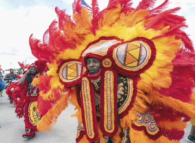 7th Ward Creole Hunters, Black Flame Hunters and Golden Comanche Mardi Gras Indians with Colombia dancers perform during the New Orleans Jazz & Heritage Festival on Friday, April 26, 2024, at the Fair Grounds Race Course in New Orleans. (Photo by Amy Harris/Invision via AP Photo)