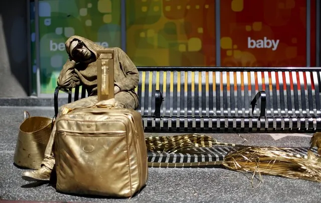 A street performer dressed in gold and wearing gold make up rests on a bench on Hollywood Boulevard in Los Angeles, U.S., April 19, 2016. (Photo by Mario Anzuoni/Reuters)