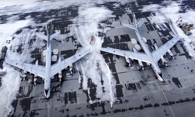 In this image taken from video provided by the Russian Defense Ministry Press Service, a pair of Tu-95 strategic bombers of the Russian air force are parked at an air base in Engels near the Volga River in Russia, Monday, January 24, 2022. Russia has intensified military drills amid tensions with the West over the buildup of an estimated 100,000 Russian troops near Ukraine that fueled Western fears of an invasion. (Photo by Russian Defense Ministry Press Service via AP Photo)