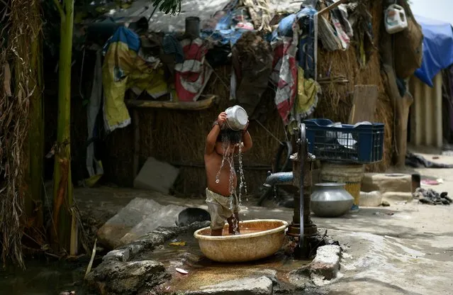 A young Indian child pours water on himself as he attempts to cool himself off in New Delhi on May 28, 2015. More than 1,100 people have died in a blistering heatwave sweeping India, authorities said, as forecasters warned searing temperatures would continue. (Photo by Money Sharma/AFP Photo)