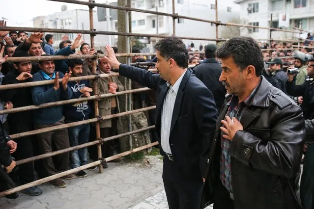 Bystanders applaud Abdolghani Hosseinzadeh (R) the father of Abdolah, an Iranian youth killed by fellow national Balal in a street fight with a knife in 2007, after he and his wife pardoned their son's convicted murderer, during his execution ceremony in the northern city of Nowshahr on April 15, 2014. The mother of Hosseinzadeh spared the life of Balal, with an emotional slap in the face as he awaited execution prior to removing the noose around his neck. (Photo by Araash Khamooshi/AFP Photo/ISNA)