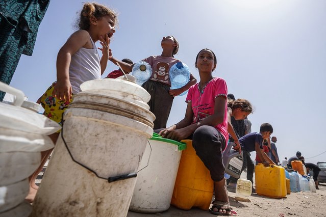 Displaced Palestinians queue for water at a camp west of Deir al-Balah in the Gaza Strip on May 21, 2024, amid the ongoing conflict between Israel and the Palestinian militant group Hamas. (Photo by AFP Photo/Stringer)