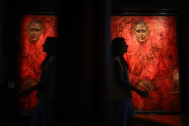 A visitor looks walks past a the new official portrait of King Charles III, painted by British artist Jonathan Yeo, and displayed at the Philip Mould gallery, on Pall Mall, central London, on May 16, 2024 following its official unveiling two days ago at Buckingham Palace. (Photo by Henry Nicholls/AFP Photo)