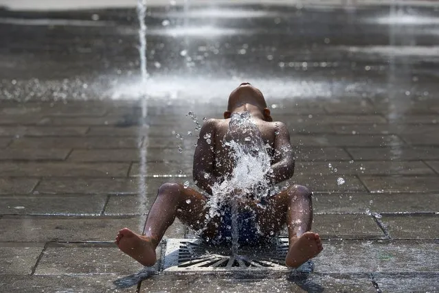 Michael, 4, plays under a fountain on a hot summer day in central Brussels, Belgium, July 2, 2015. The United Nations warned on Wednesday of the dangers posed by hot weather, especially to children and the elderly, as much of Europe sweltered in a heatwave whose intensity it blamed on climate change. (Photo by Yves Herman/Reuters)