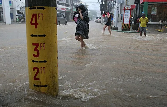 A flood warning gauge (L) is seen along a flooded road after tropical storm Linfa hit San Fernando, La Union in northern Philippines July 5, 2015. (Photo by T. J. Corpuz/Reuters)