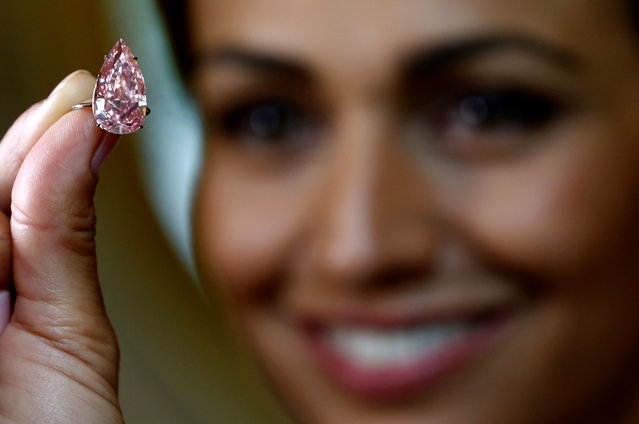 A model poses with “The Unique Pink” diamond mounted during a preview at Sotheby's auction house in Geneva, Switzerland May 9, 2016. The supremely rare and exceptional Fancy Vivid Pink diamond, weighting 15.38 carats, is estimated to sell for US $ 28 to 38 million, when auctioned during the Magnificent Jewels and Noble Jewels auction in Geneva on May 17. (Photo by Denis Balibouse/Reuters)