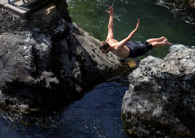A man jumps into Treska river to cool off from hot weather near Skopje, North Macedonia on June 17, 2024. (Photo by Ognen Teofilovski/Reuters)